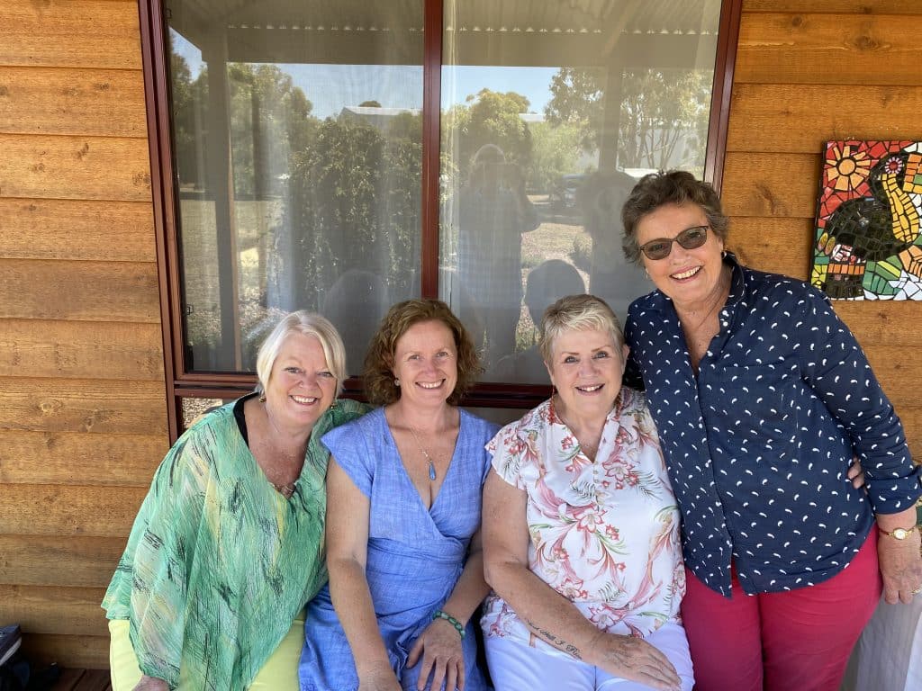 Four middle aged to senior women smiling outside a yoga studio in Mortlake, Victoria