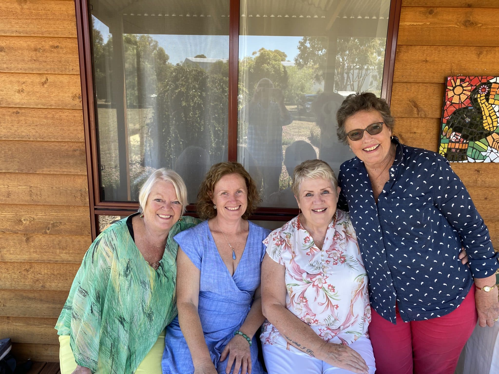 Four middle aged to senior women smiling outside a yoga studio in Mortlake, Victoria